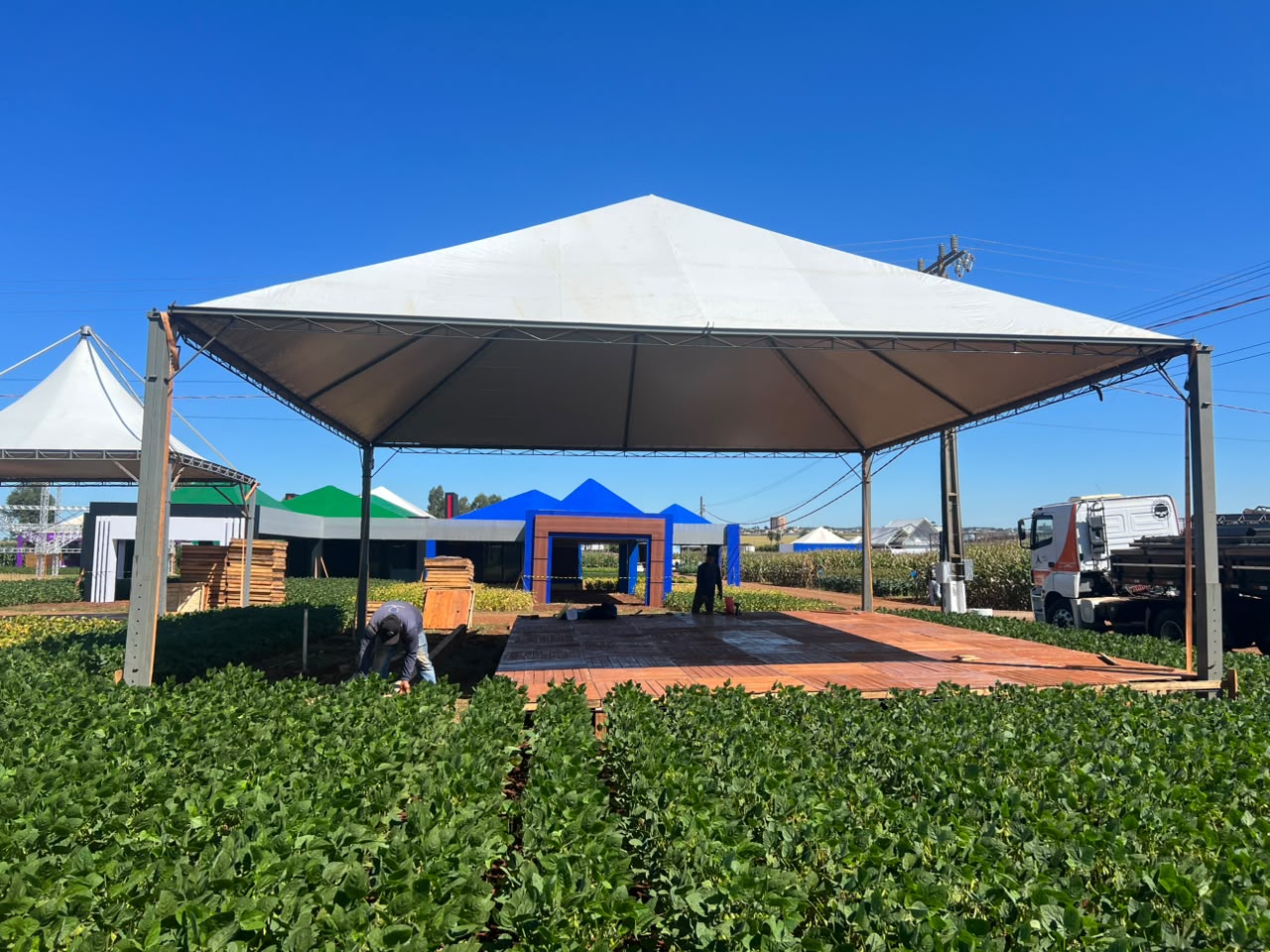 Tenda de grande vão montada sobre piso de madeira em feira agrícola